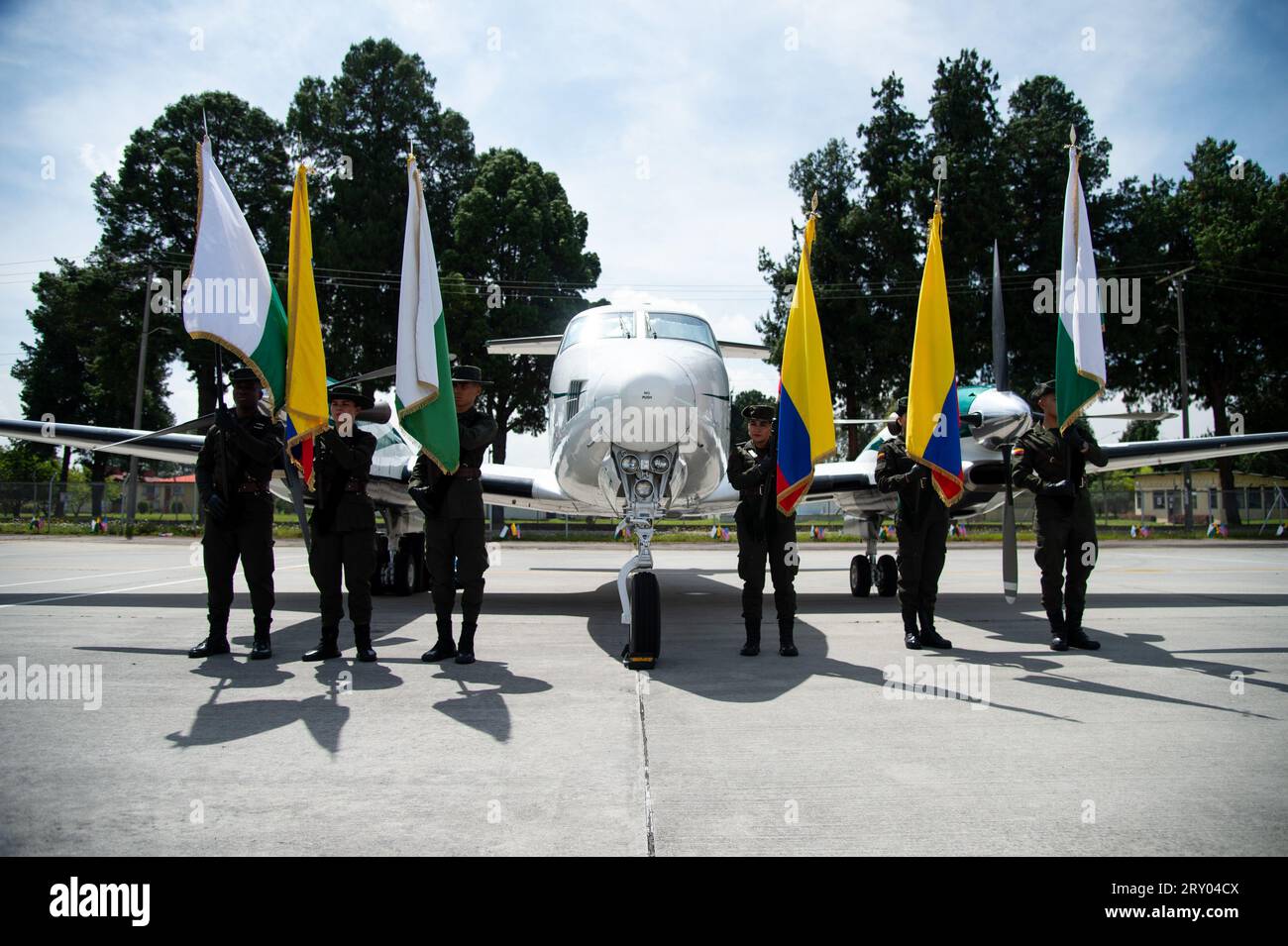 Colombia's antinarcotics police officers hold flags in front of a plane during an event at the CATAM - Airbase in Bogota, where the United States of America embassy in Colombia gave 3 Lockheed Martin UH60 Black Hawks to improve the antinarcotics operations, on September 27, 2023. Photo by: Chepa Beltran/Long Visual Press Stock Photo