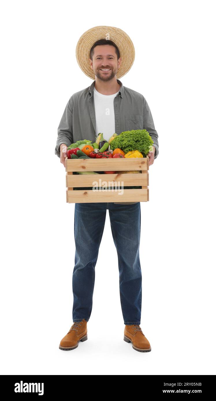 Harvesting season. Happy farmer holding wooden crate with vegetables on ...