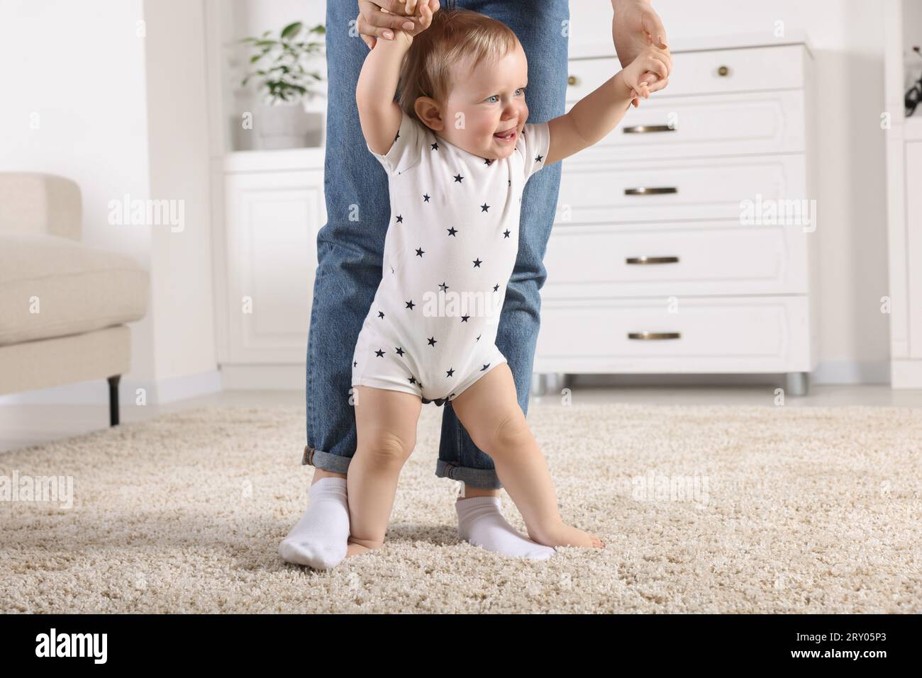 Walk On Rug Mother supporting her baby son while he learning to walk on carpet at ...