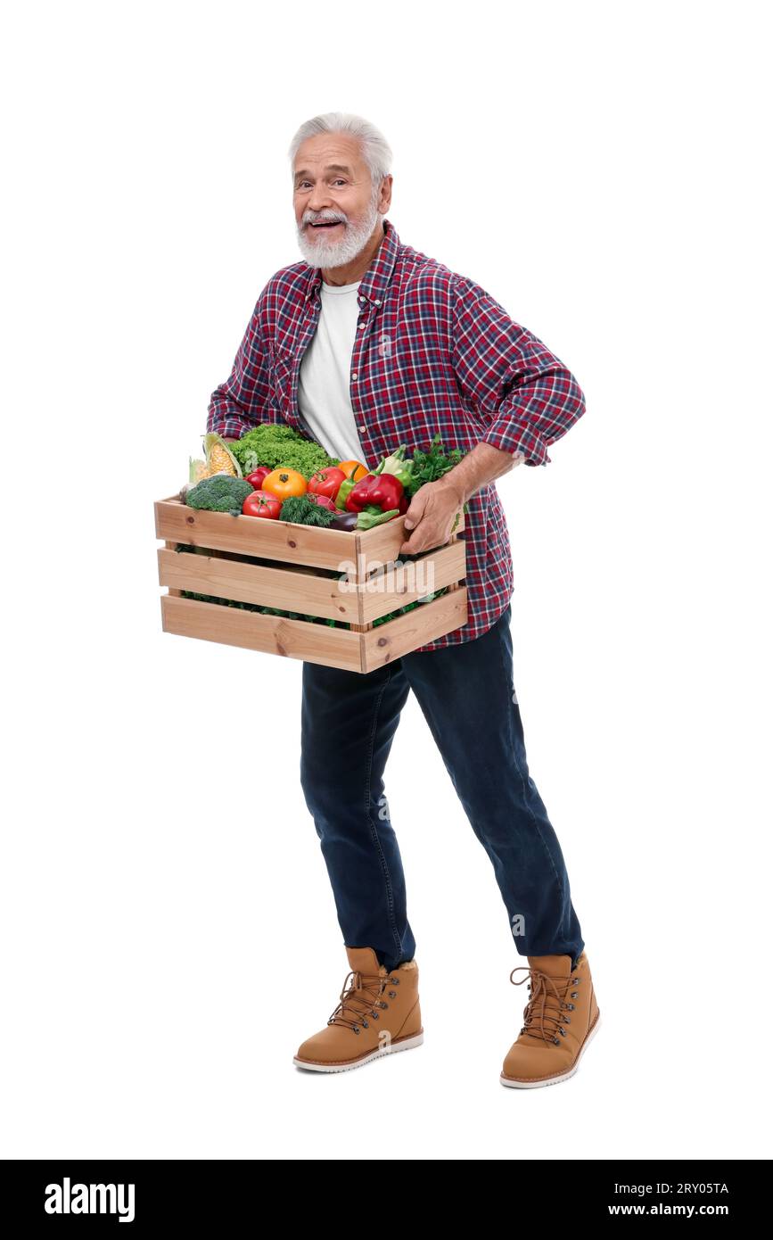 Harvesting season. Happy farmer holding wooden crate with vegetables on ...