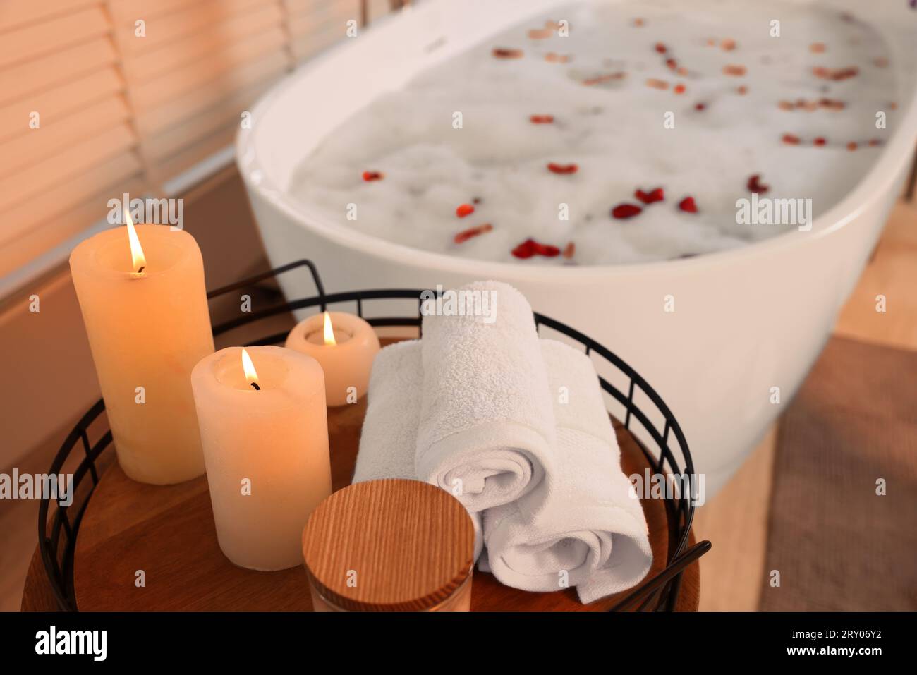 Man relaxing in bathtub with lighted candles arround stock photo