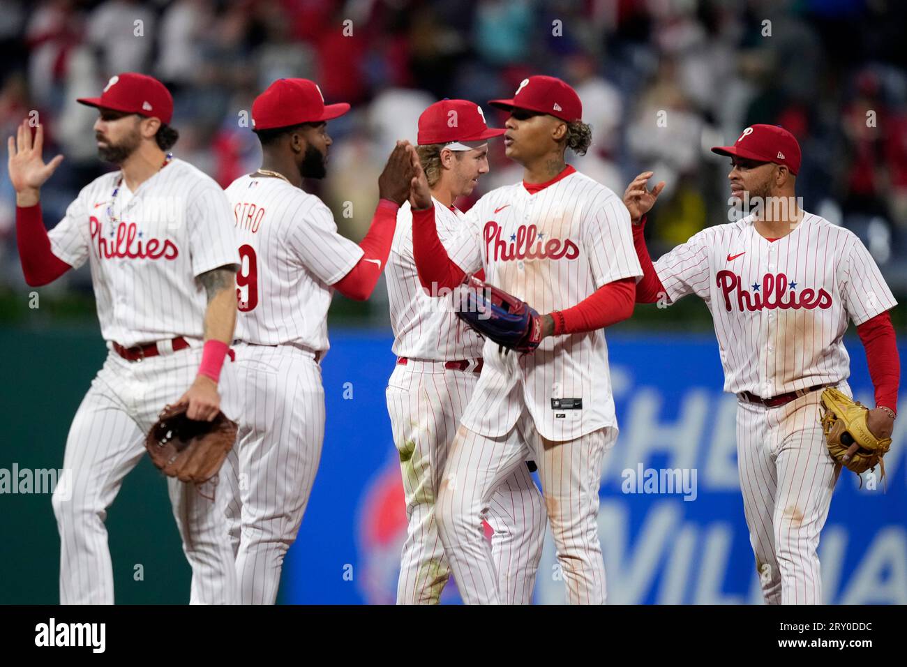 Philadelphia Phillies' Jake Cave, center, gets the water treatment from  Brandon Marsh, right, and Bryson Stott, left, as Alec Bohm, far left,  throws sunflower seeds at him from the dugout after the