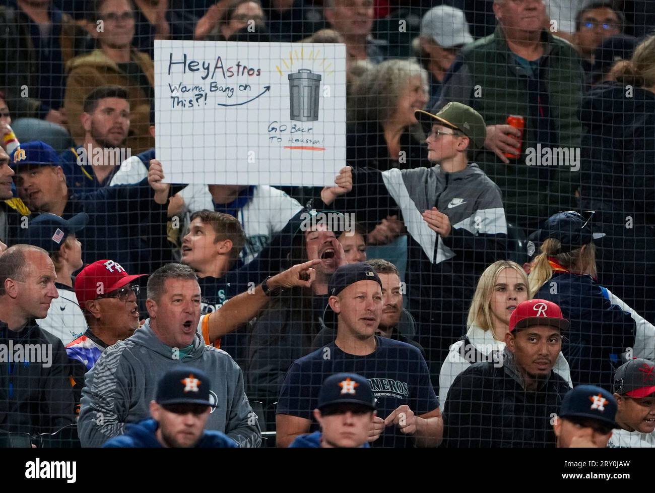 A fan holds a sign referencing the Houston Astros with an image of