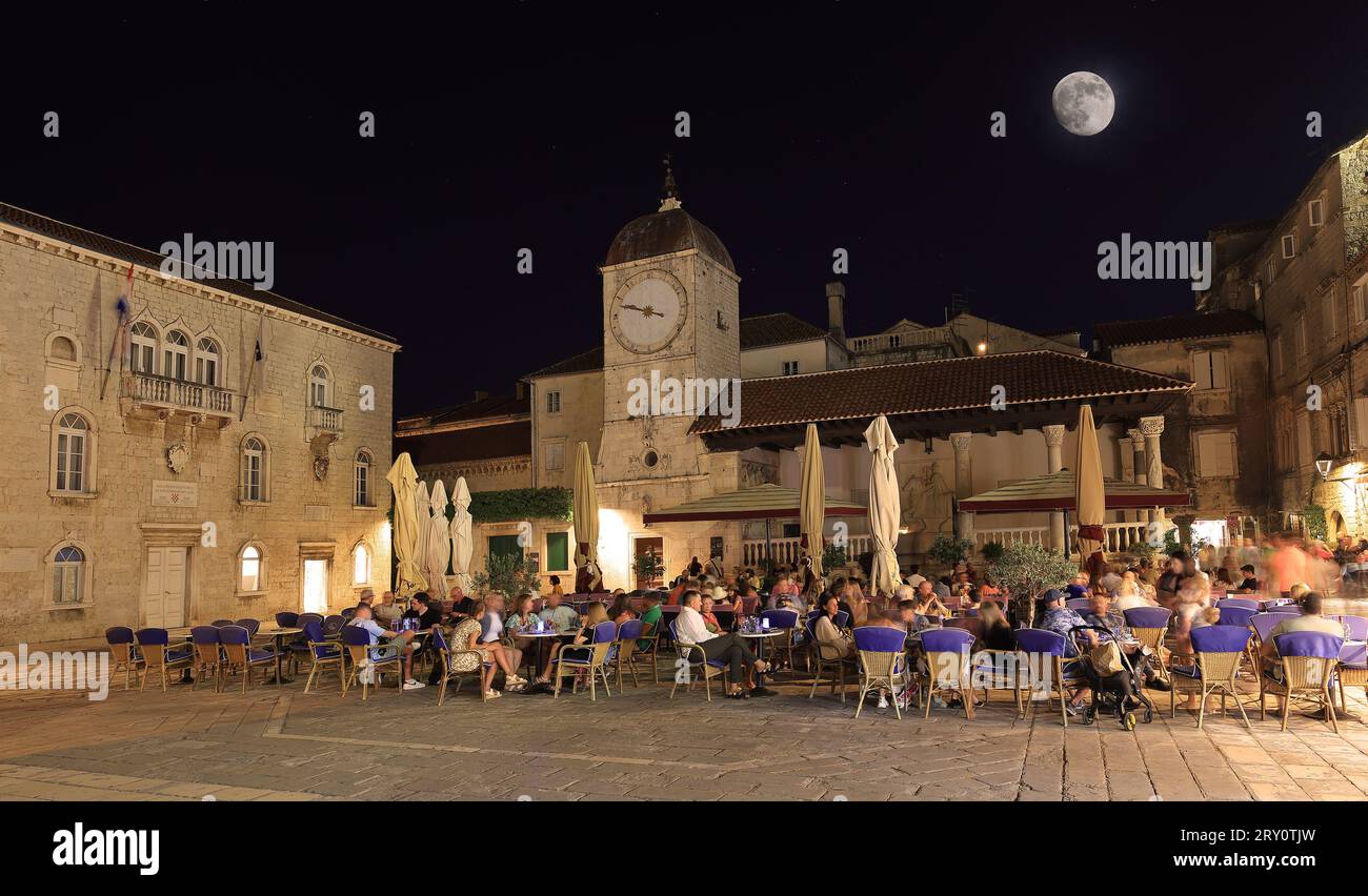 Tourists enjoying restaurants in UNESCO Town of Trogir main square at night, Croatia Stock Photo