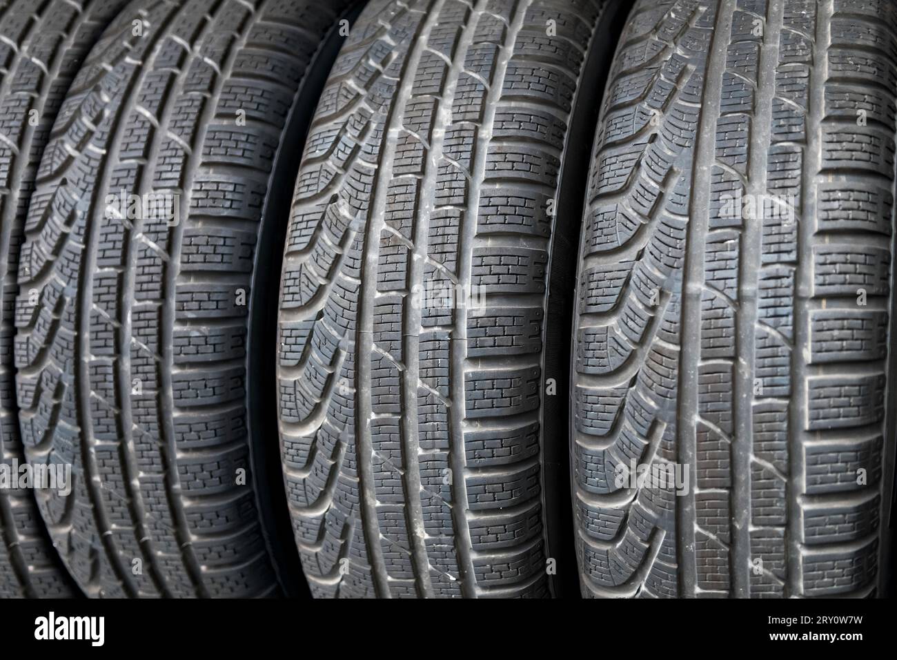 Closeup of rough huge winter tires designed with ornamental pattern and textured to suit frost and snow terrain while stacked together in full frame i Stock Photo