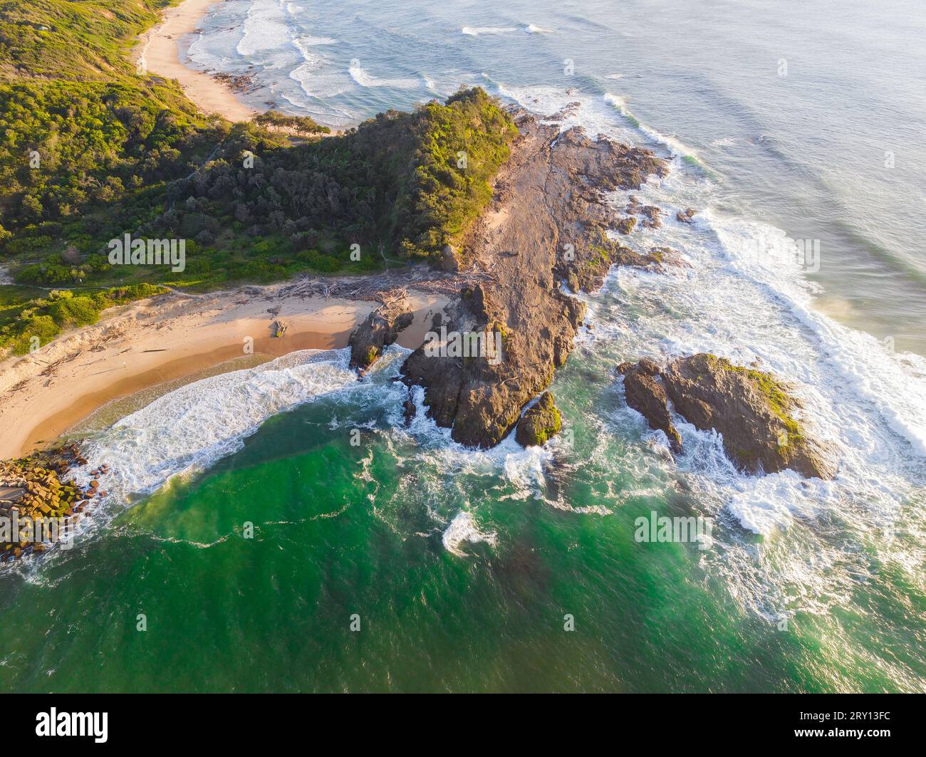 Aerial view of waves crashing against a rocky headland at Nambucca Heads in New South Wales