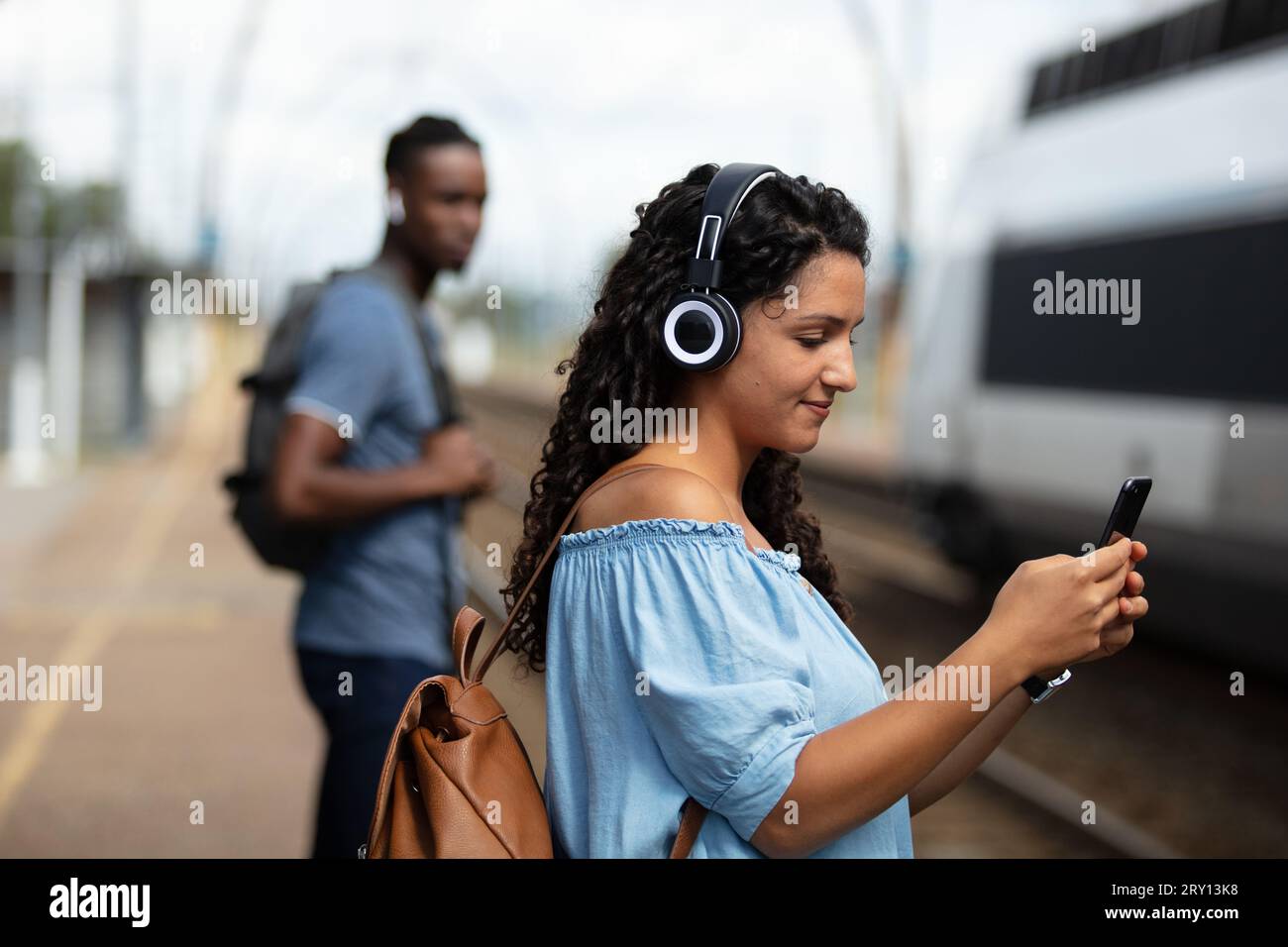 Woman waiting train listening hi-res stock photography and images - Alamy