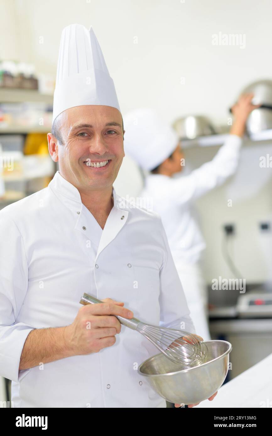 happy male chef whisking in bowl Stock Photo Alamy