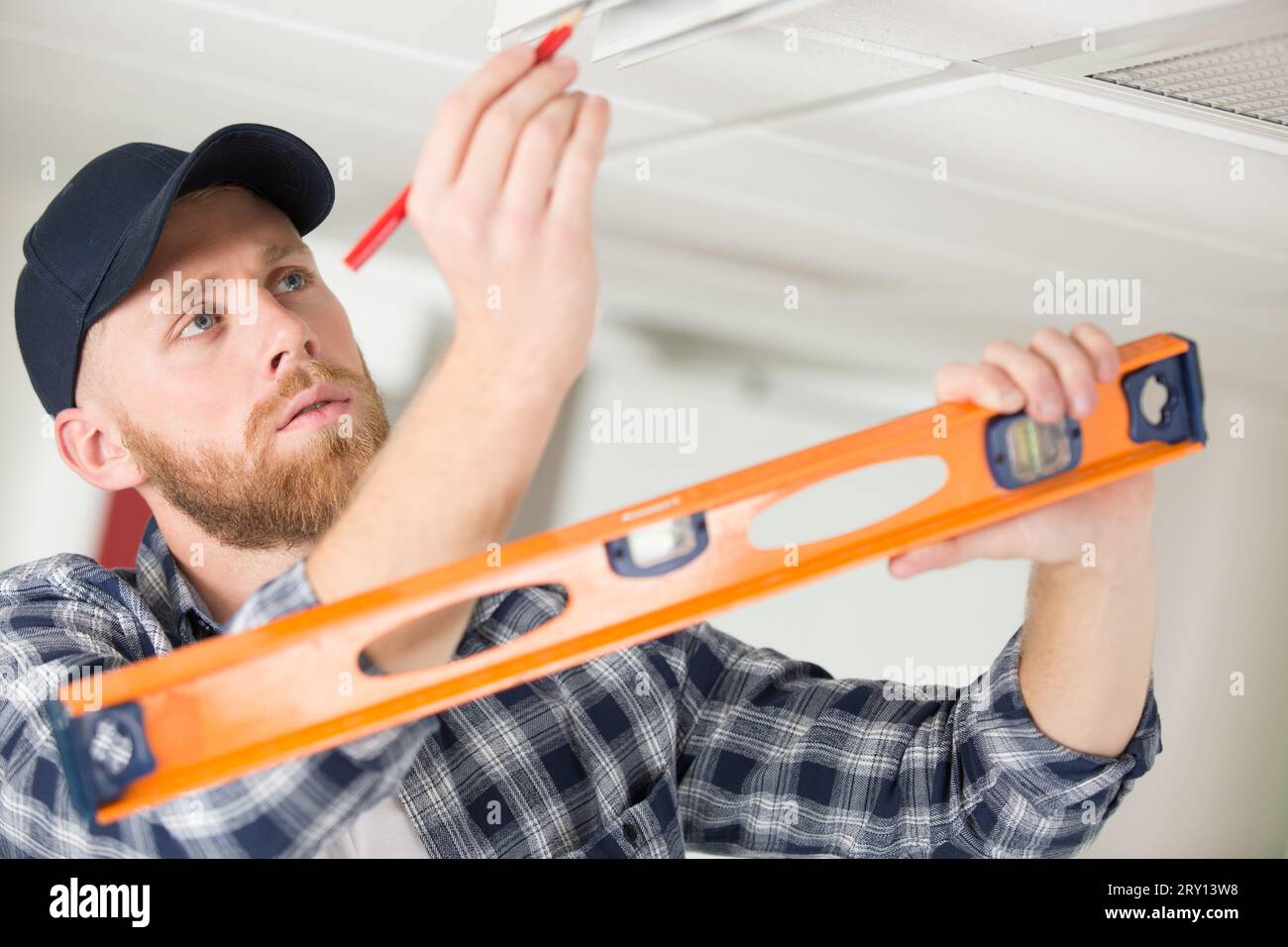 taking ceiling measures with spirit level Stock Photo