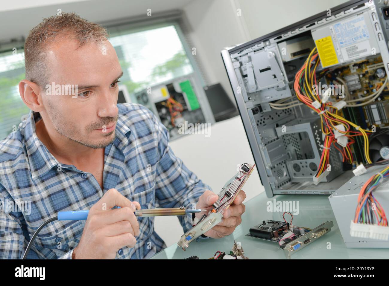 Computer expert fixing a printed circuit Stock Photo