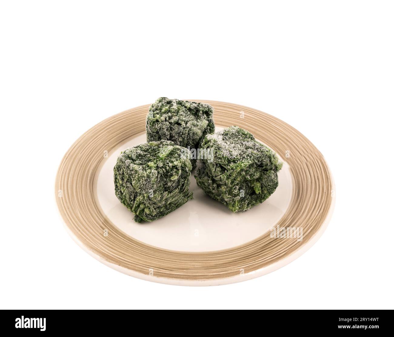 frozen spinach leaves in cubes on the plate on a transparent background