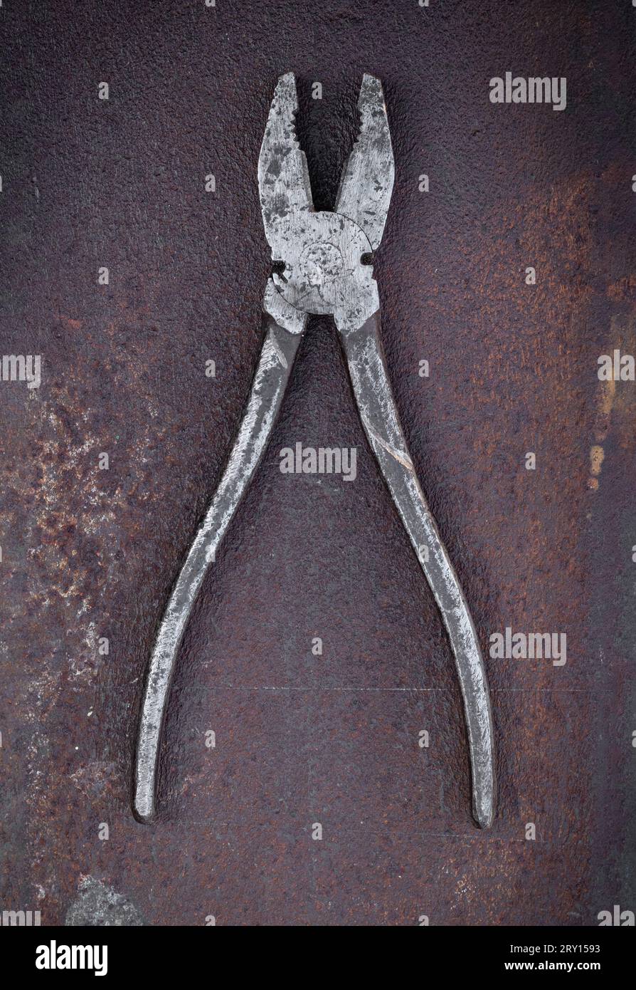 Old pliers lie on a piece of rusty metal Stock Photo