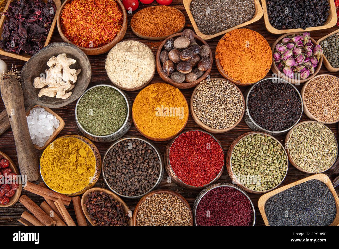 Colorful background with various herbs and spices for cooking in bowls. Seamless texture with spices and herbs. Stock Photo