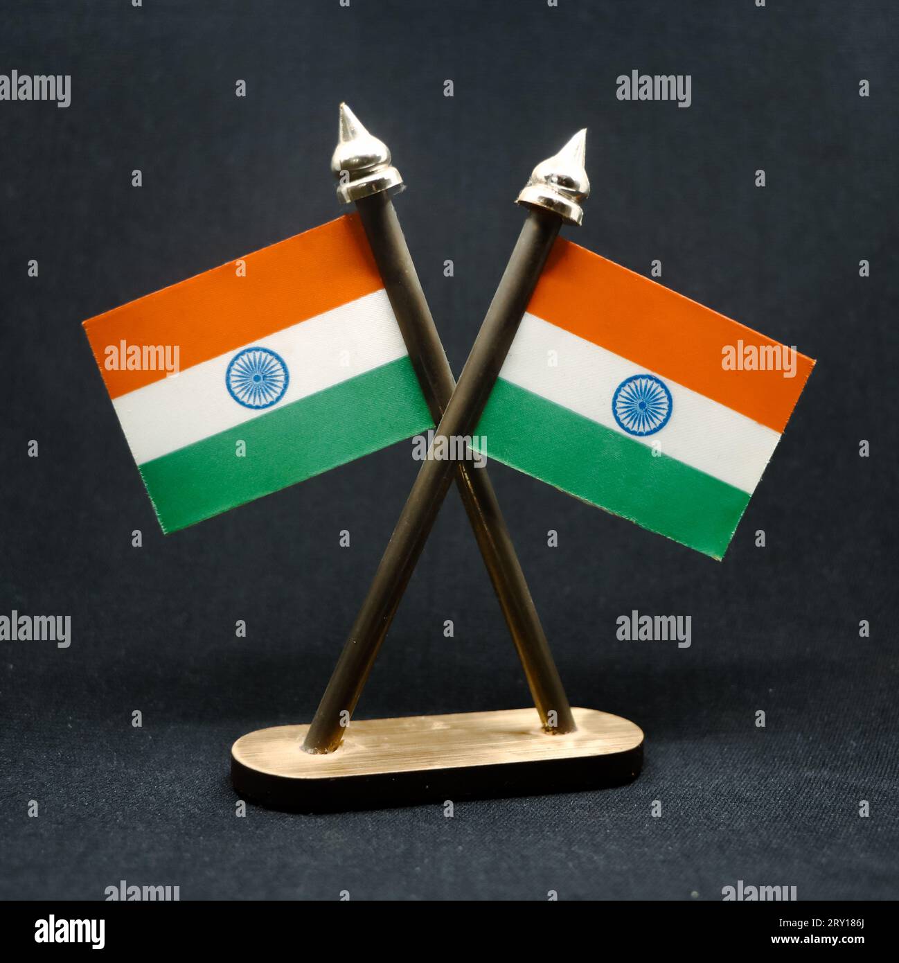 The national flag of India in republic tricolors with the ashoka chakra fixed on two poles isolated in a black background Stock Photo