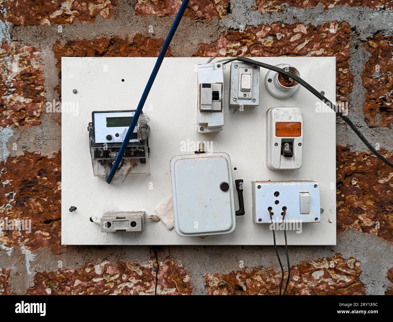 an electrical power outlet with wired cable connections, switches , fuse and electricity voltage reading meter on the wall Stock Photo