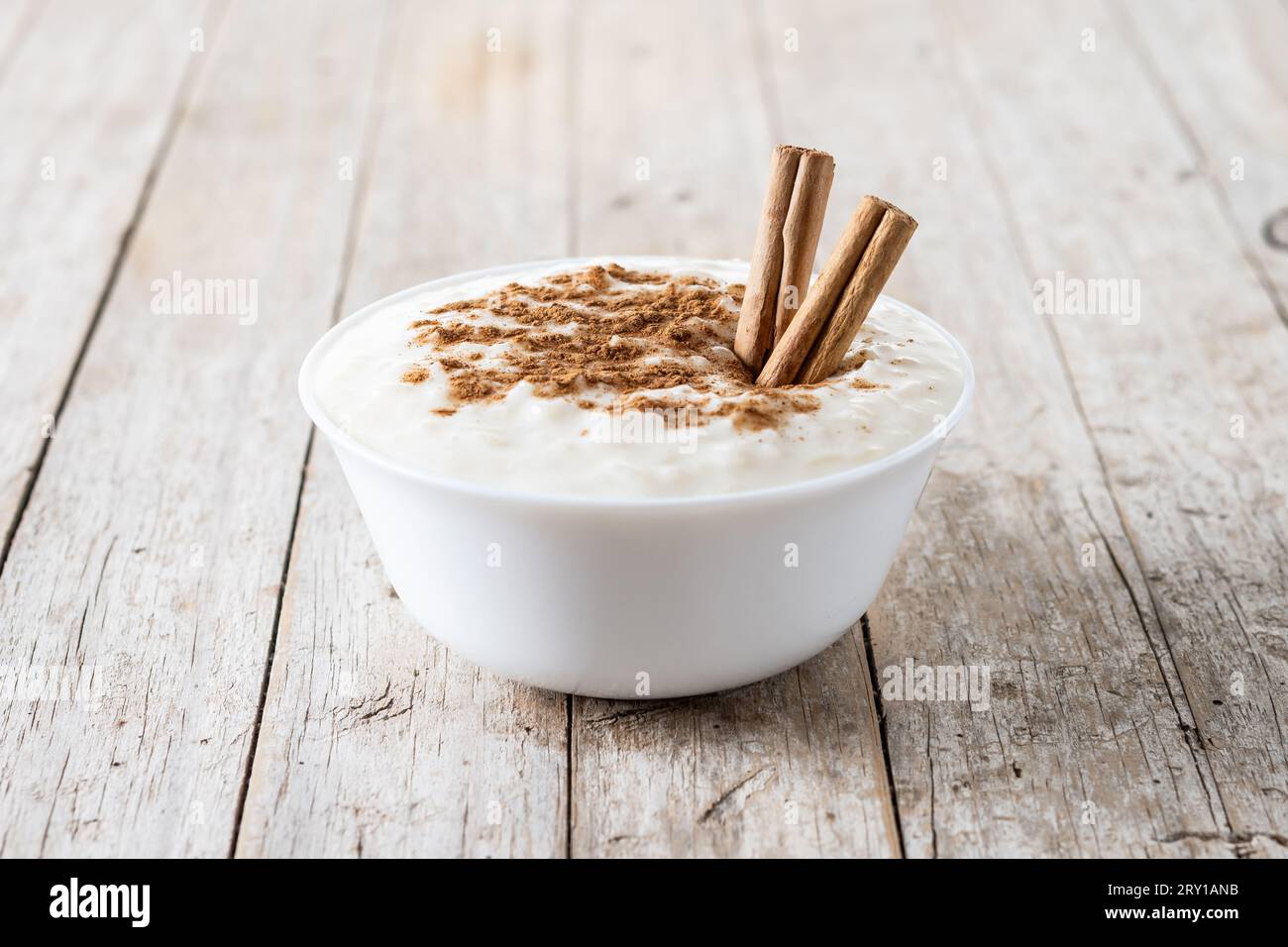 Arroz con leche. Rice pudding with cinnamon in bowl on wooden table Stock Photo