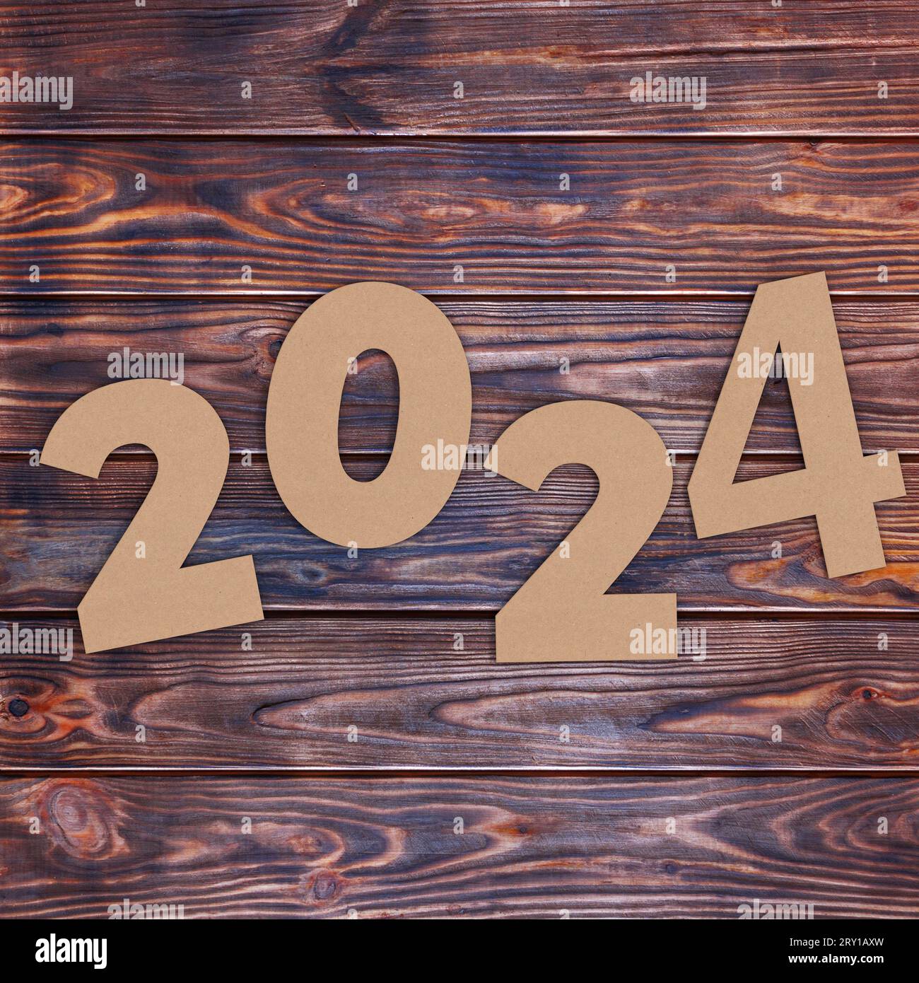 Cardstock Numbers 2024 Happy New Year Sign over wooden table background