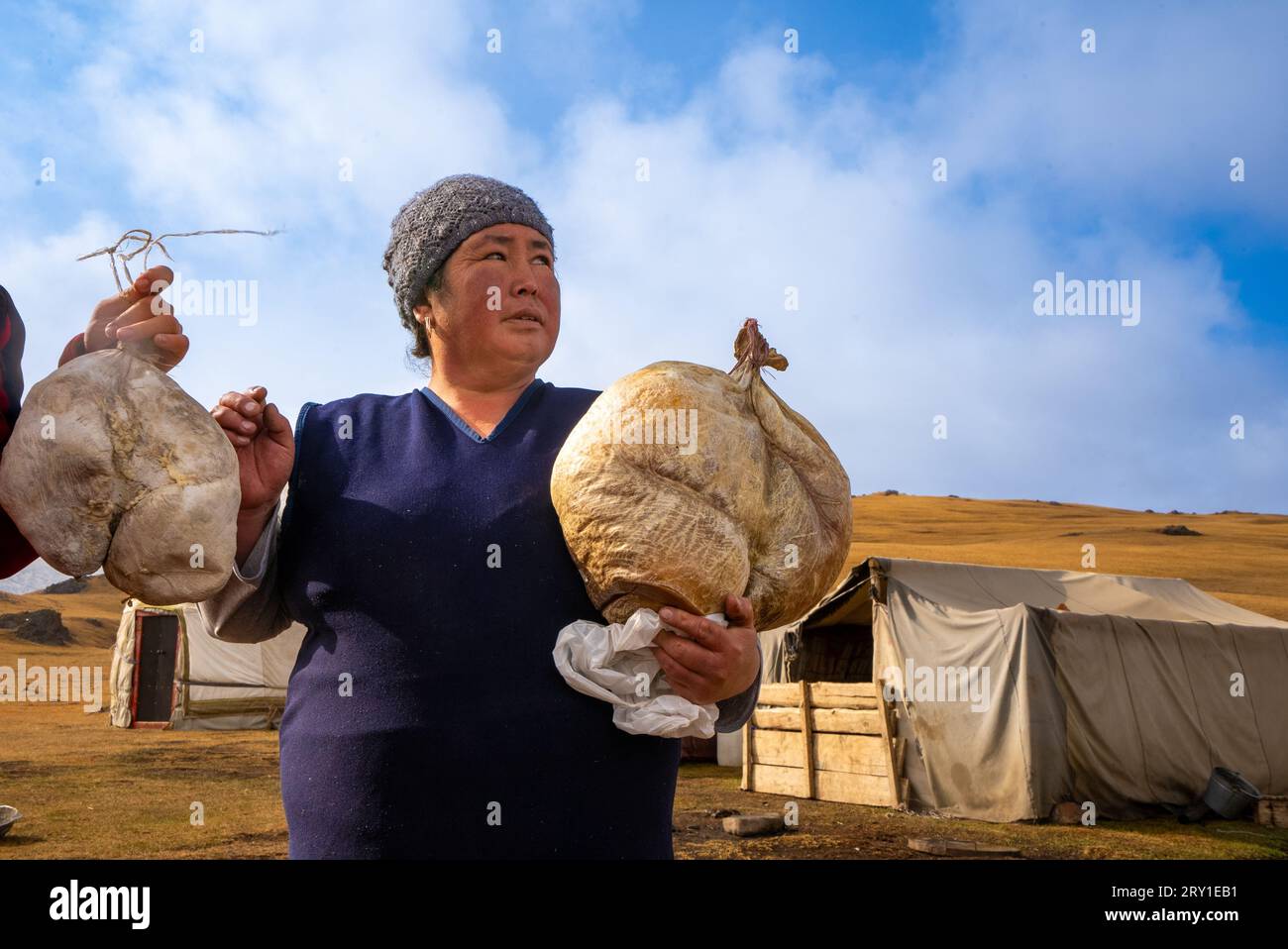 Kyrgyz shepherd woman with traditional cheese inside a goat skin kyrgyzstan Stock Photo