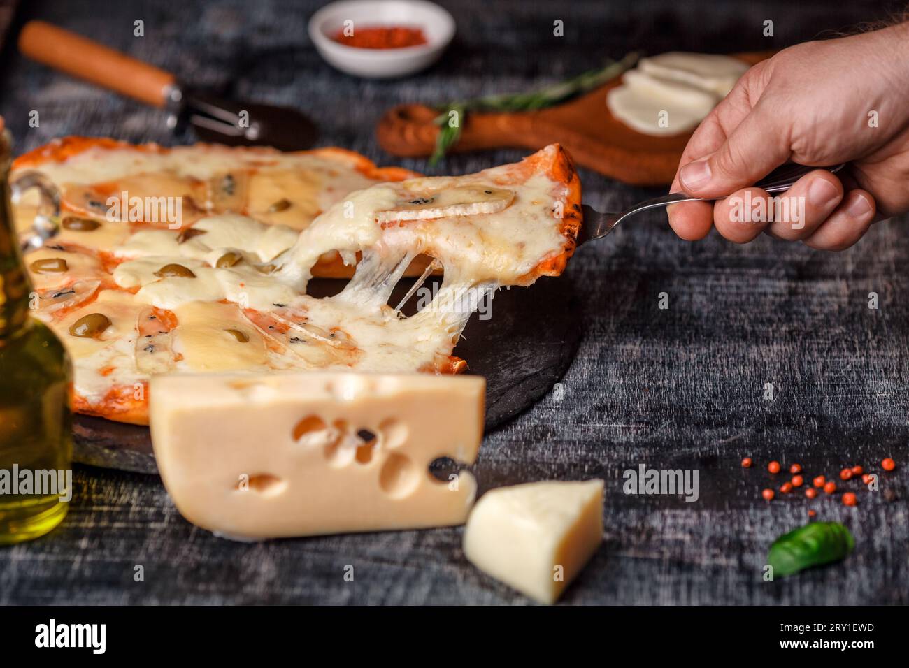 Italian pizza with different sorts of cheese on a stone and a black scratched chalk board