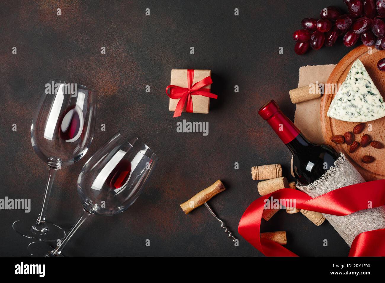 Bottle of wine, gift box, red grapes, blue cheese, almonds, corkscrew