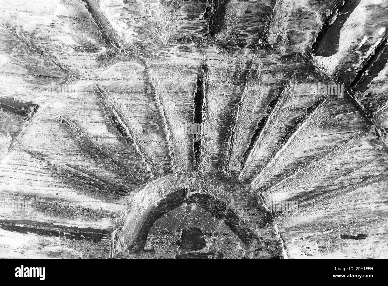 A wooden carving of the sun and its rays in a black and white ...