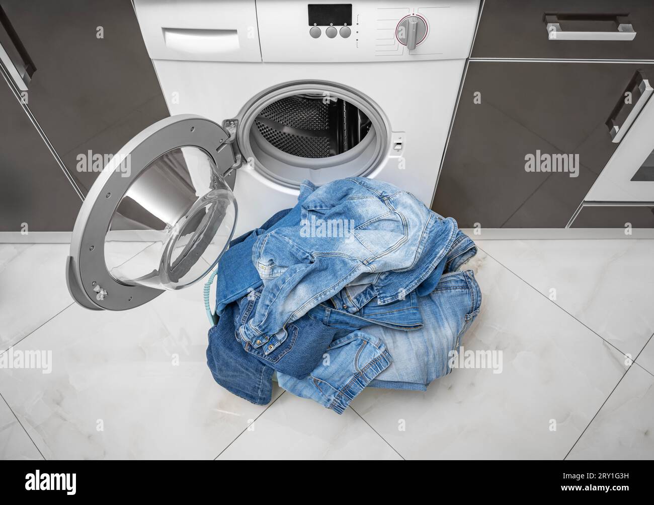 Washing denim items in the washing machine. Stock Photo