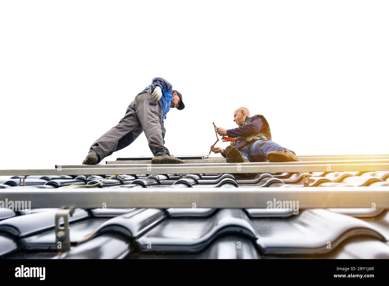 Technicians standing on the solar panel mounting rack on the roof of a house Stock Photo
