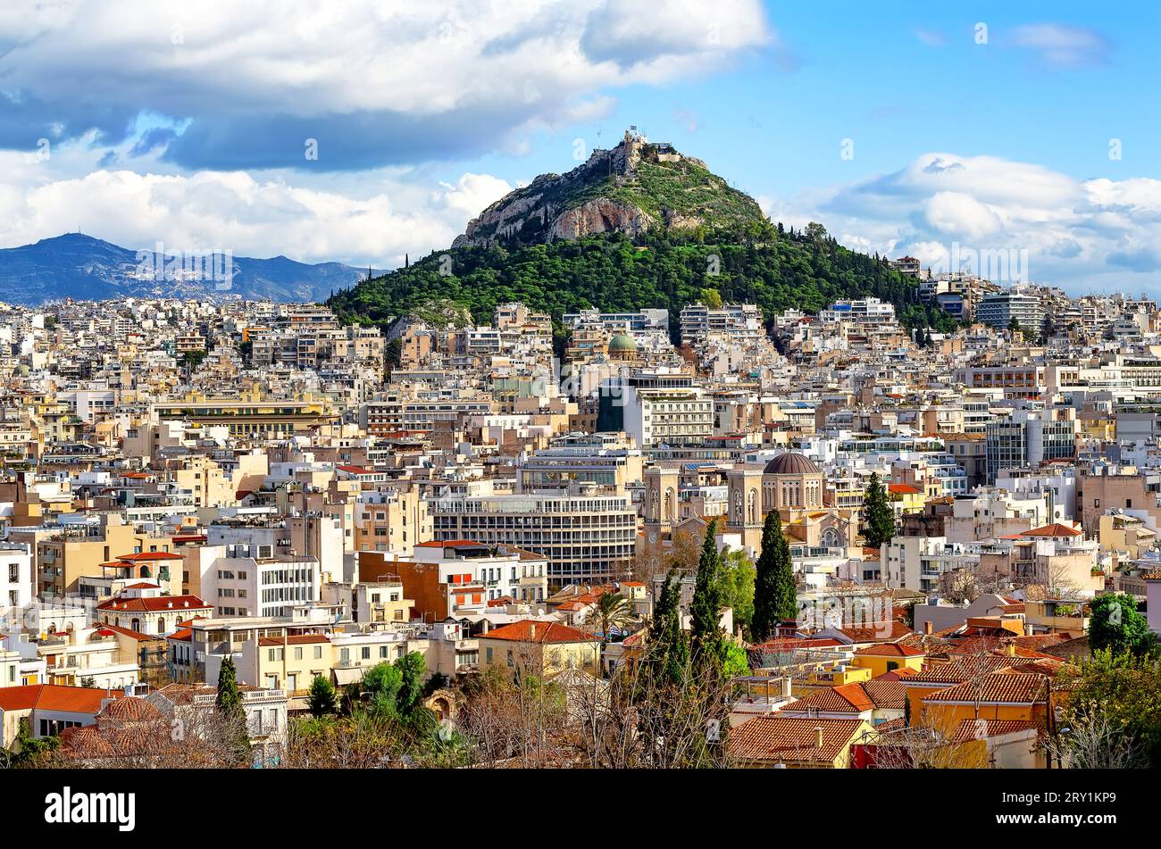 View of Lycabettus mount from Acropolis hill in Athens, Greece. Cityscape of historical town of Athens with old and modern Greek houses. Stock Photo