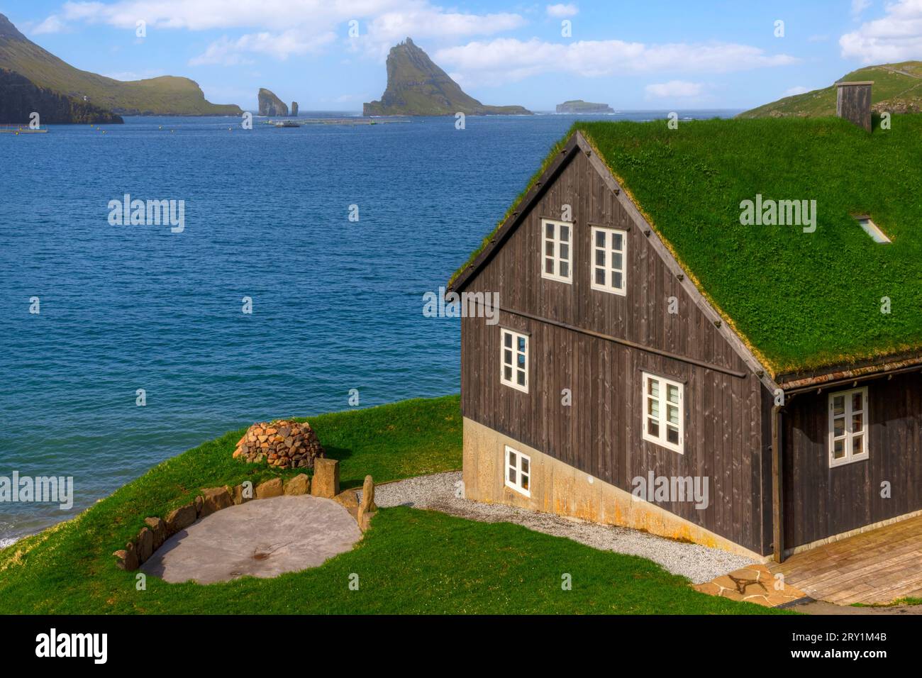 Turfed Houses and sea stack Tindholmur in Bour, Faroe Islands Stock Photo