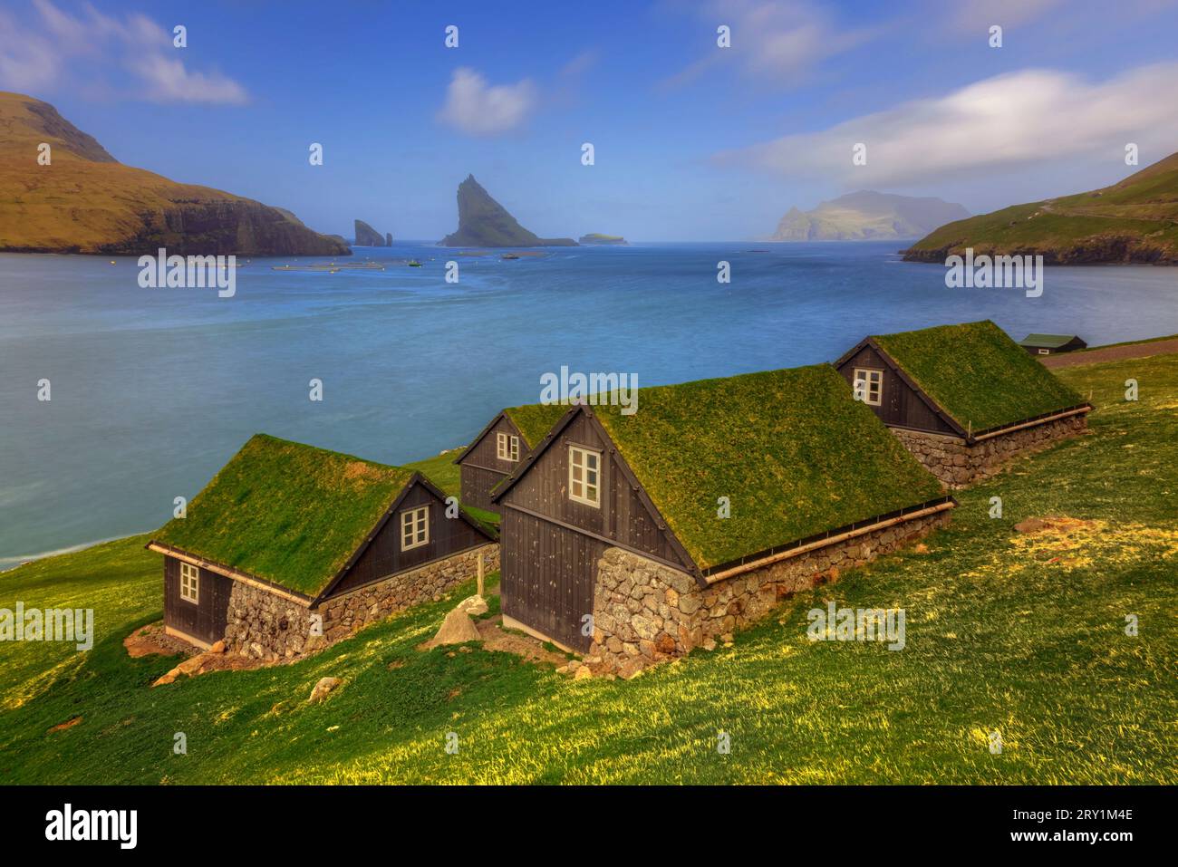 Turfed Houses and sea stack Tindholmur in Bour, Faroe Islands Stock Photo