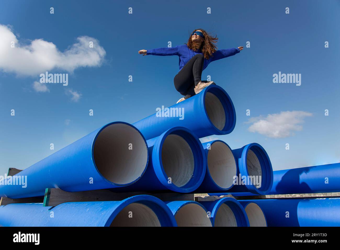 Woman in blue on blue pipes. Stock Photo