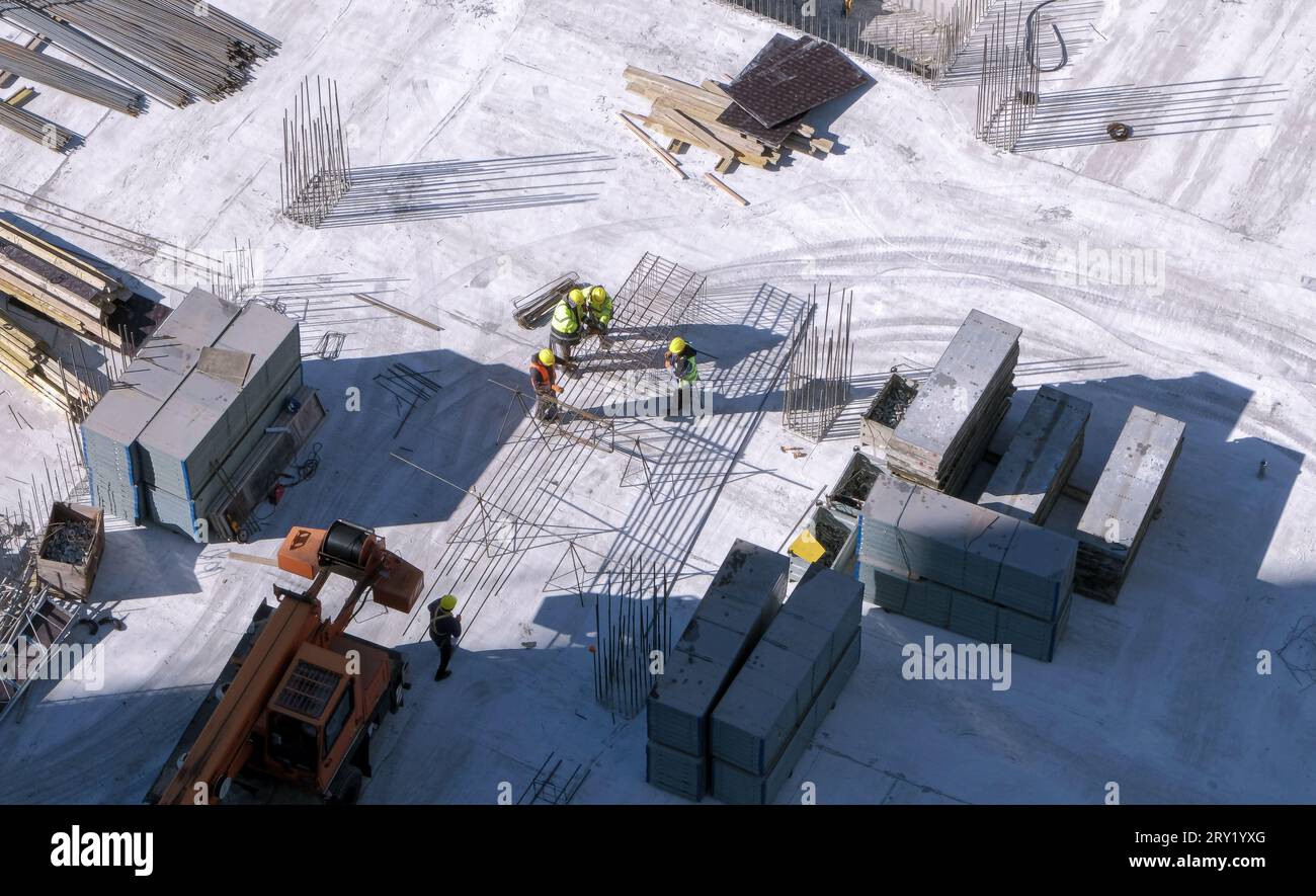 Group of builders working with a metal rebars at the construction site