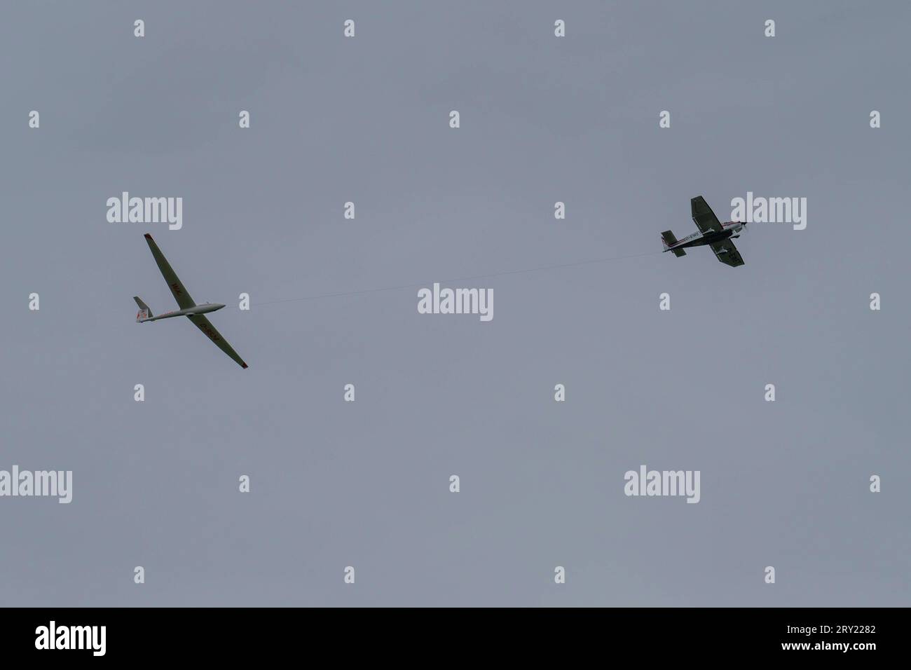 Ein Segelflugzeug wird von einem Motorflugzeug vom Sonderlandeplatz auf der 950 Meter hohen Wasserkuppe bei Gersfeld Landkreis FuldaIn der Rhön in Hessen in die Höhe gezogen. *** A glider is pulled aloft by a powered aircraft from the special landing field on the 950 meter high Wasserkuppe near Gersfeld County of Fulda In the Rhön Mountains in the German state of Hesse Stock Photo