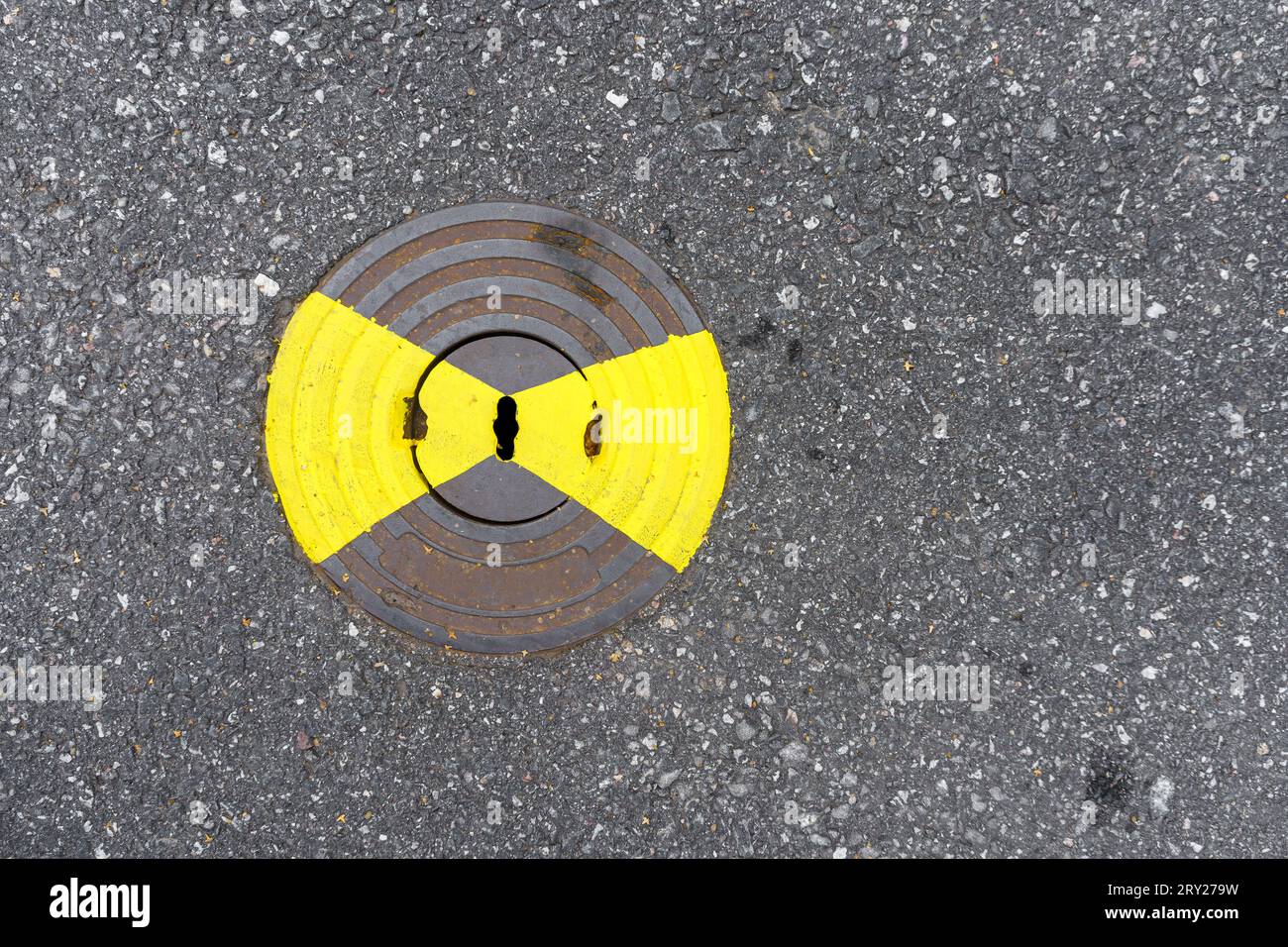 Gas utility manhole cover with yellow paint on asphalt, top view. Stock Photo