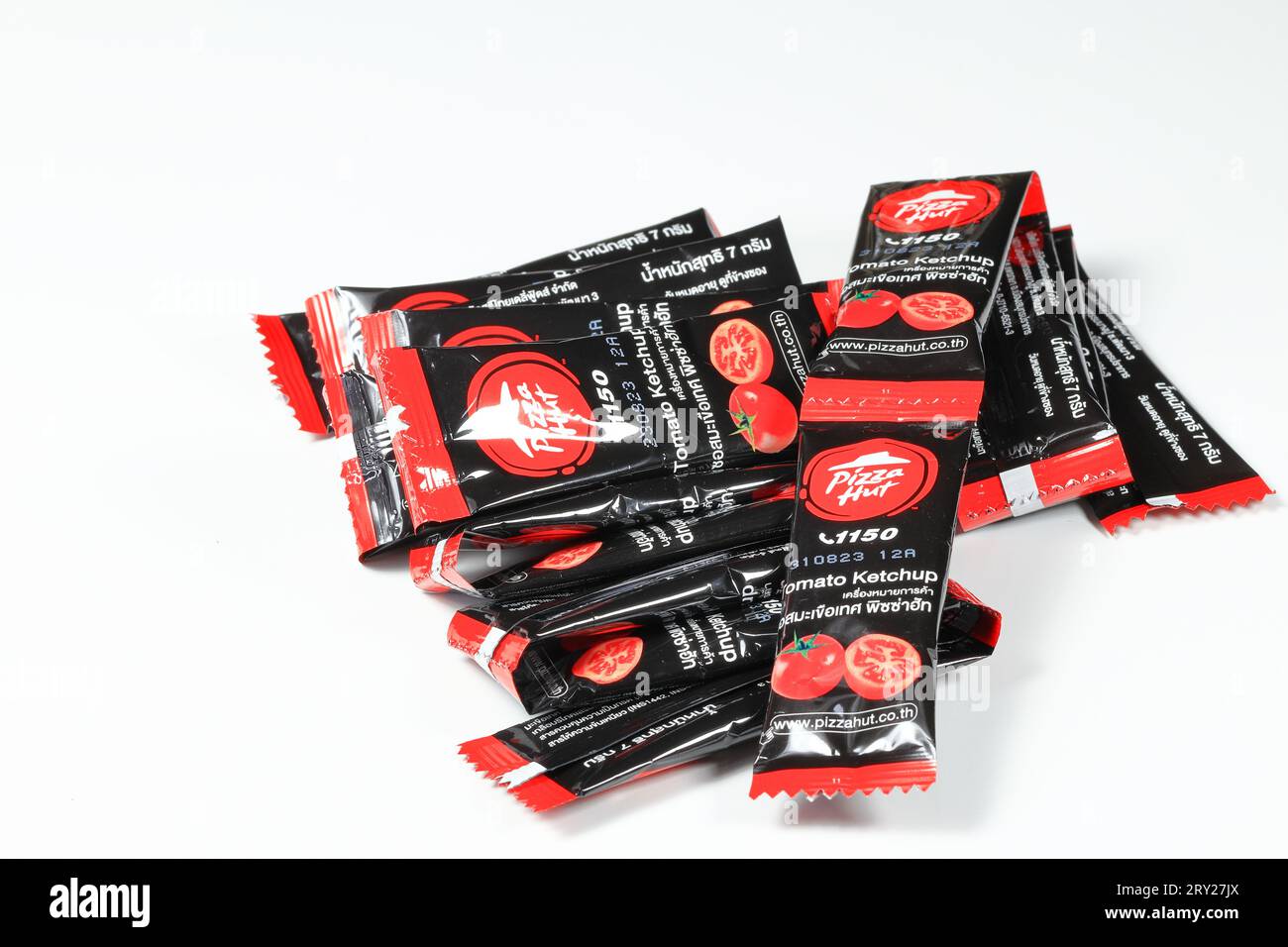 Pile of seasoning packets or sachet Of Pizza Hut, an American restaurant chain. ketchup or tomato sauce with small black packaging or sachet packet. Stock Photo