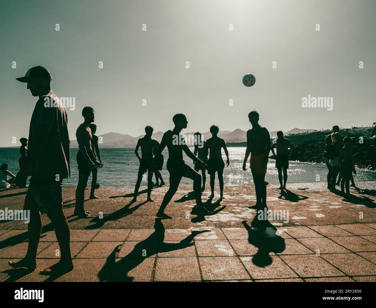 Group of kids playing football on a pier in summer Stock Photo