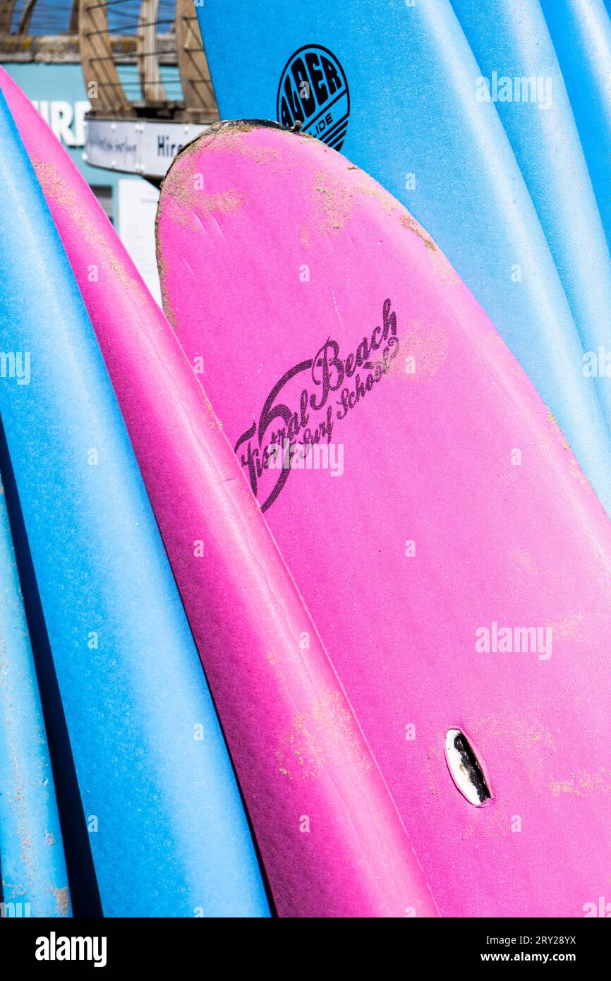 Colourful surfboards stacked and available to hire at the surf hire