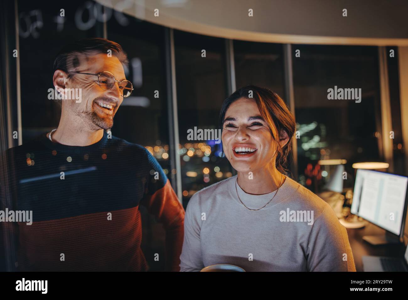 Tow business professionals and analysts brainstorm and plan for success in a nighttime meeting. business team collaborating, sharing ideas and working Stock Photo