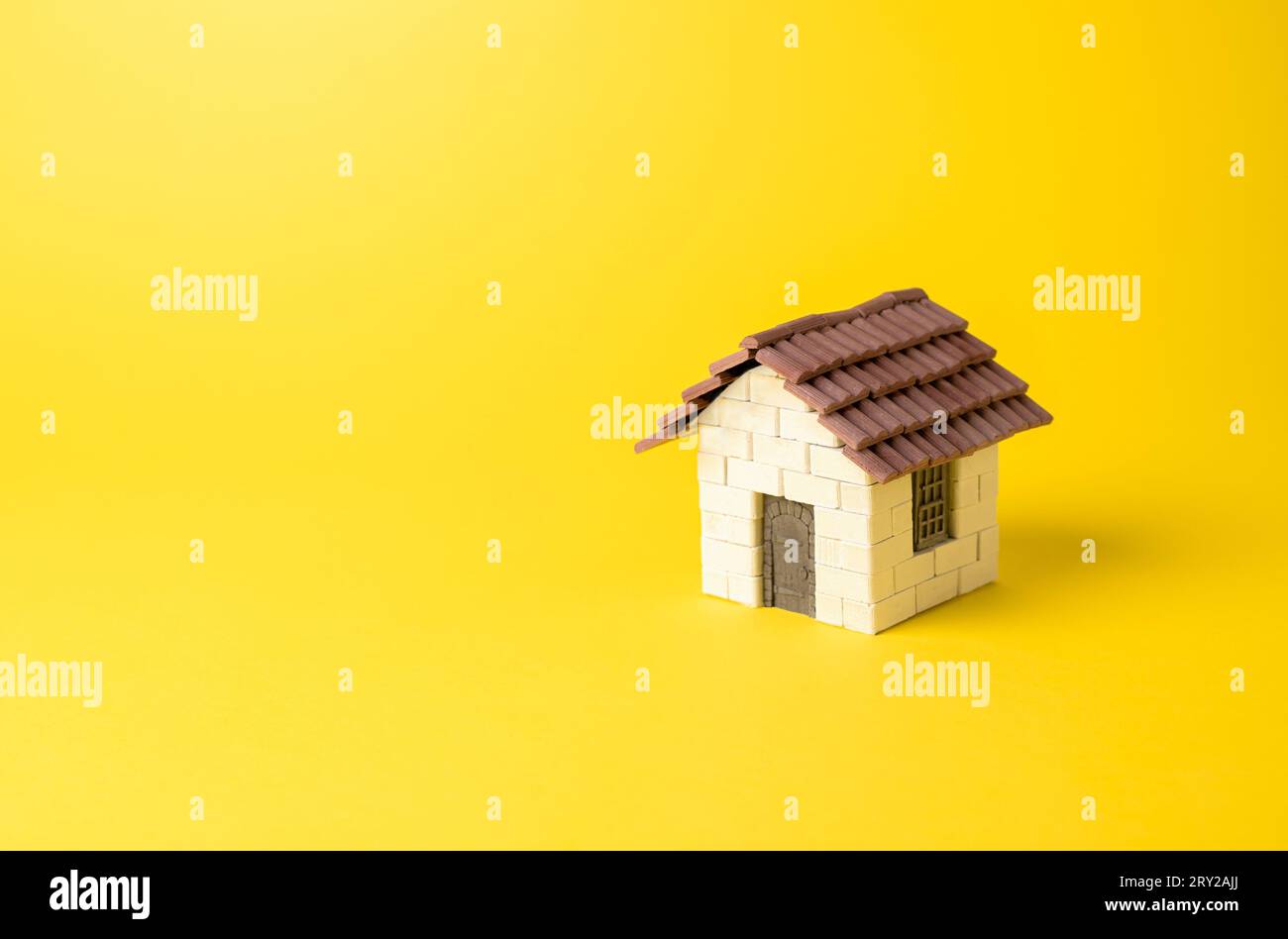 Residential house on a yellow background. Buying and selling housing. Property insurance. Design and architectural services. Real estate market review Stock Photo
