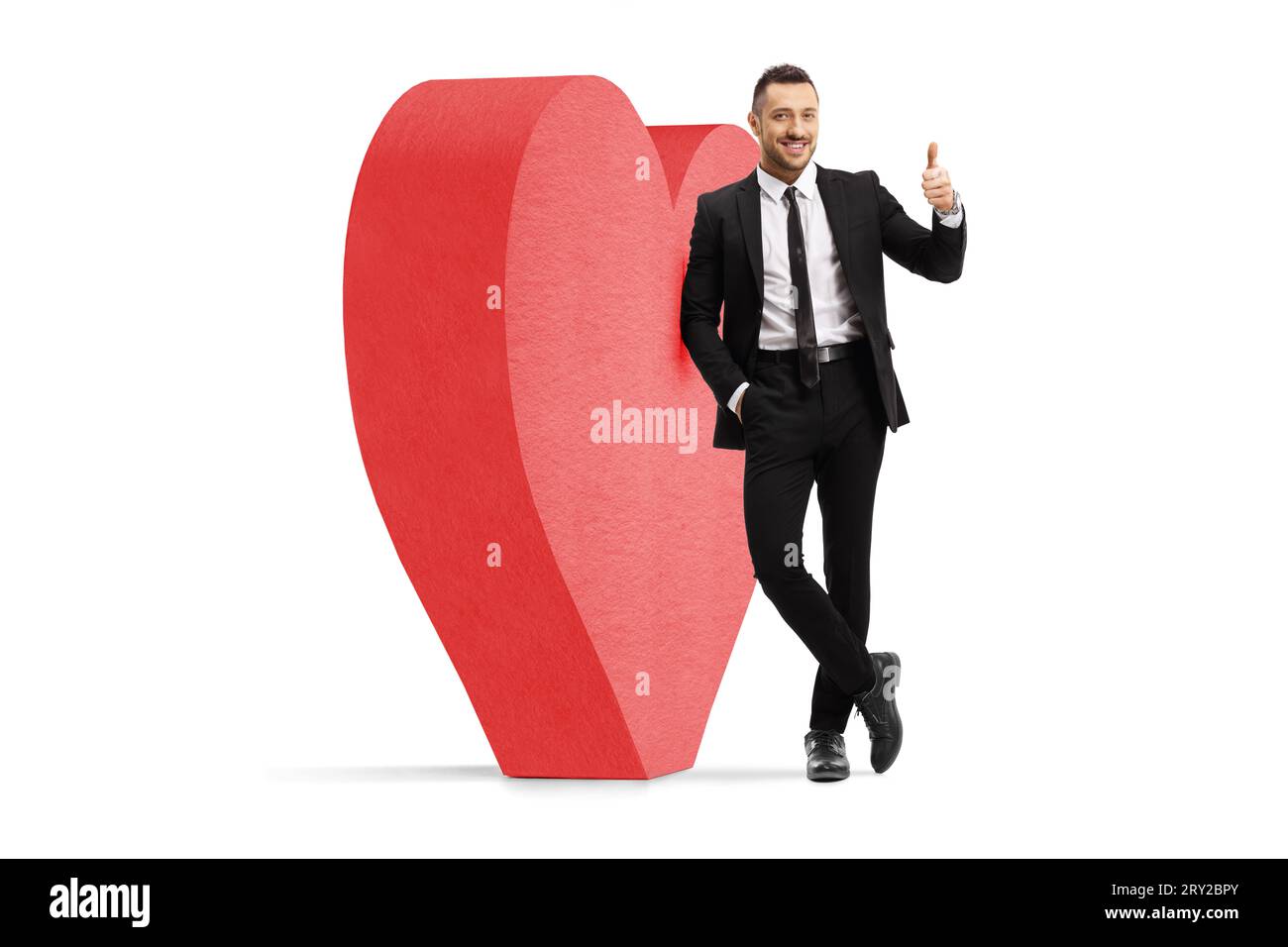 Romantic Professional Man Next To A Big Red Heart Gesturing Thumbs Up romantic-professional-man-next-to-a-big-red-heart-gesturing-thumbs-up