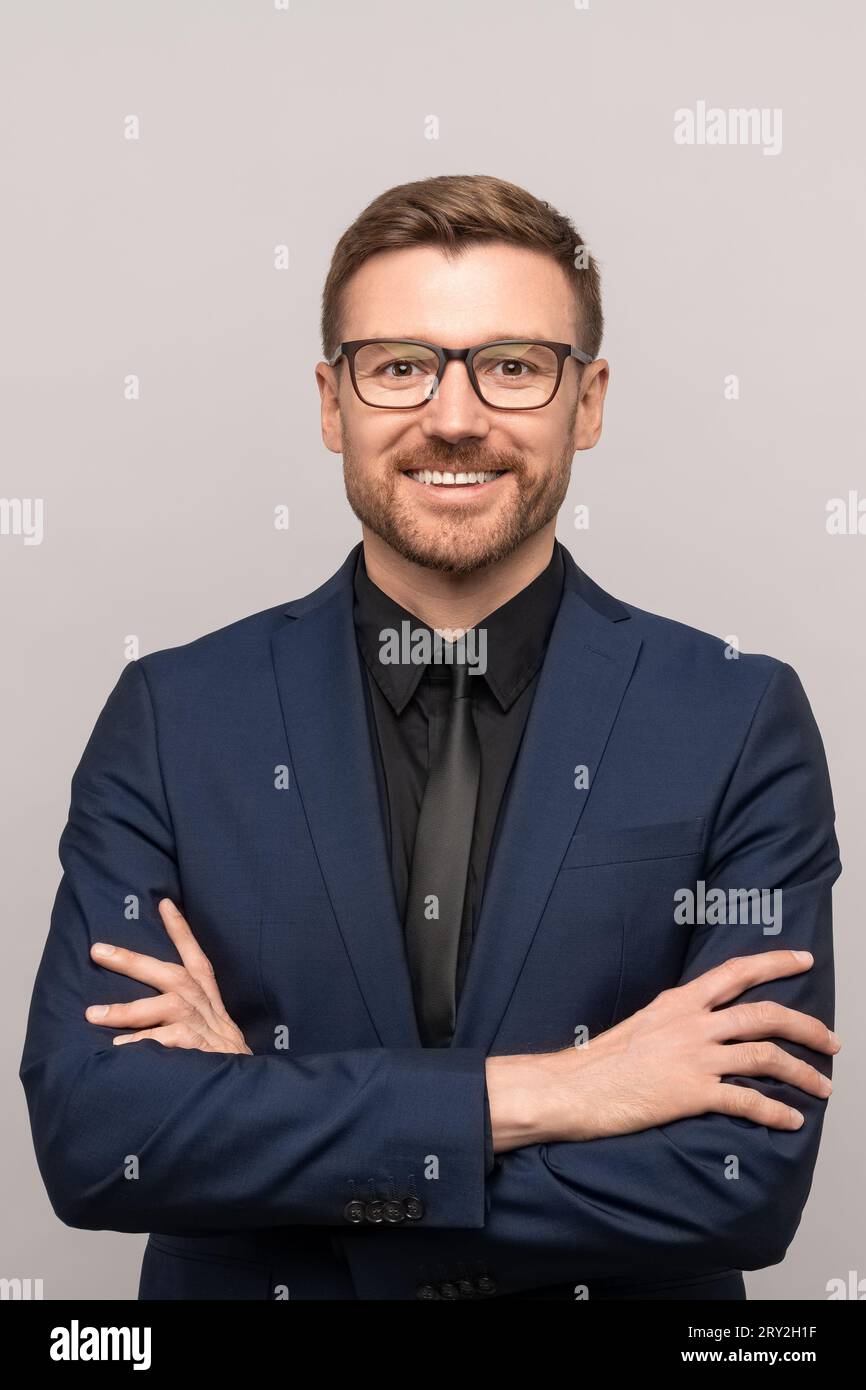 Happy successful confident businessman in suit with crossed arms on ...
