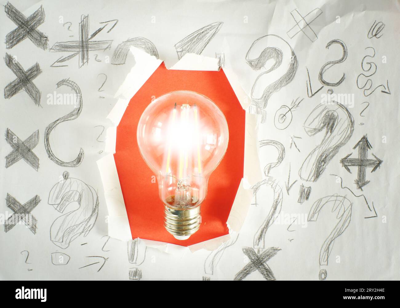 Lightbulb inside of punch paper with scribble and question marks for ...