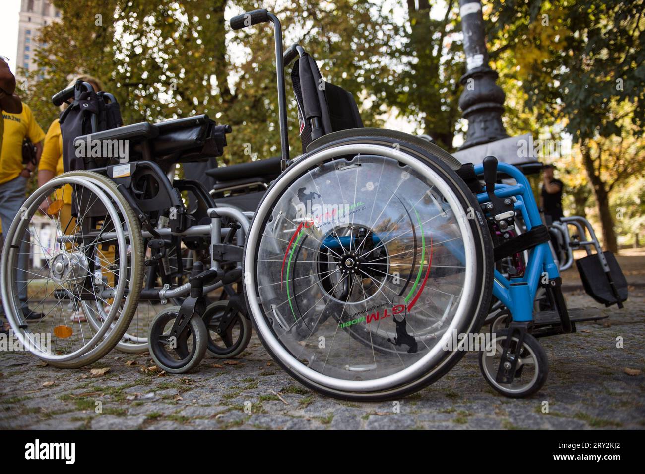 Warsaw, Poland - 28 Sep 2023 Empty wheelchairs are seen during the 'We are all EQUALLY IMPORTANT' march. A march organized by the Poland 2050 political party (Polska 2050) under the slogan 'We are all EQUALLY IMPORTANT' (Wszyscy Jestemy ROWNOWAZNI) led by Lukasz Krason, passed through the streets of Warsaw. Participants wore yellow T-shirts (color of the party); some of them pushed empty strollers to symbolize people who may experience disabilities in the future. 'People with disabilities want a system that lends a hand in difficult moments. This is what this march is about, this is what my el Stock Photo