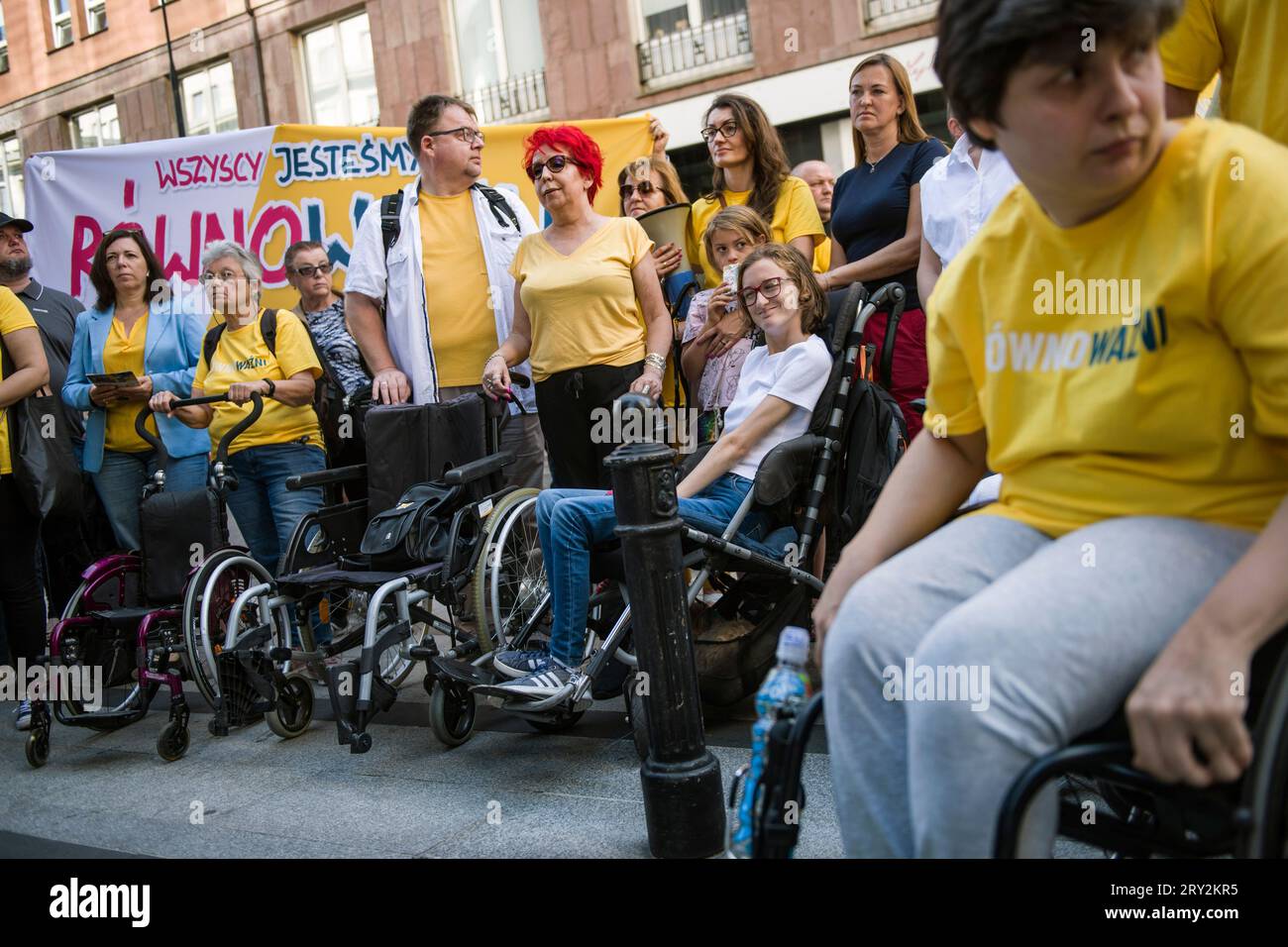 Warsaw, Poland - 28 Sep 2023 People with disabilities and their caregivers attend to the 'We are all EQUALLY IMPORTANT' march. A march organized by the Poland 2050 political party (Polska 2050) under the slogan 'We are all EQUALLY IMPORTANT' (Wszyscy Jestemy ROWNOWAZNI) led by Lukasz Krason, passed through the streets of Warsaw. Participants wore yellow T-shirts (color of the party); some of them pushed empty strollers to symbolize people who may experience disabilities in the future. 'People with disabilities want a system that lends a hand in difficult moments. This is what this march is abo Stock Photo