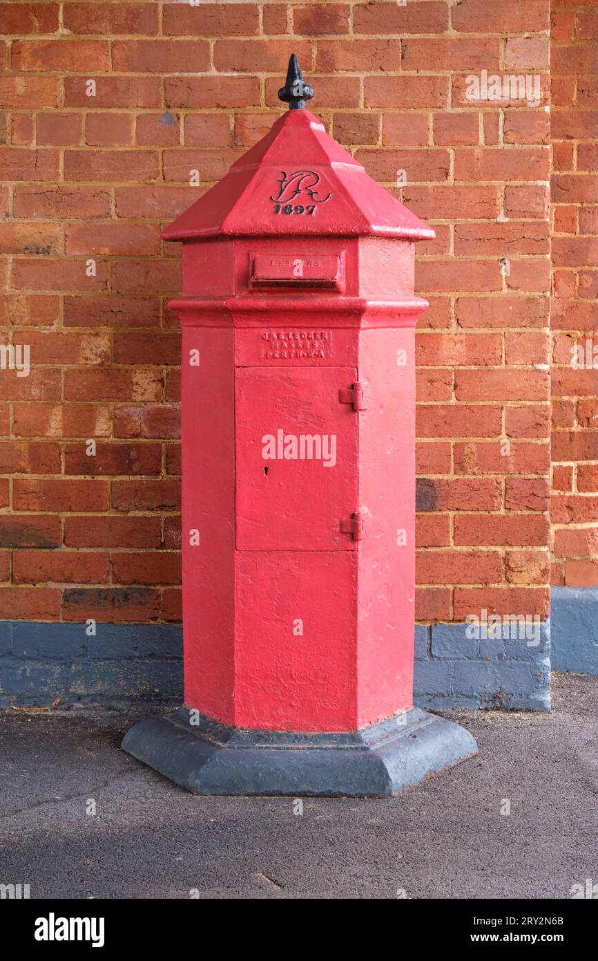 An historical red post box from 1897 made by J & E Ledger Makers located at the historical Narrogin Railway Station in Western Australia. Stock Photo