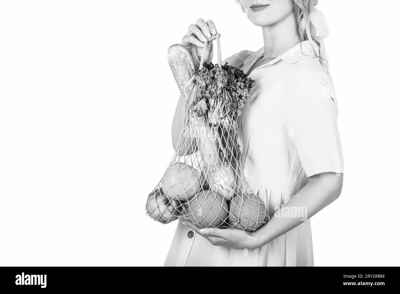 Ingredient in healthy, dietary and vegetarian food. Zero waste concept. Girl holding cotton eco bag organic fruits, vegetables. Black and white Stock Photo