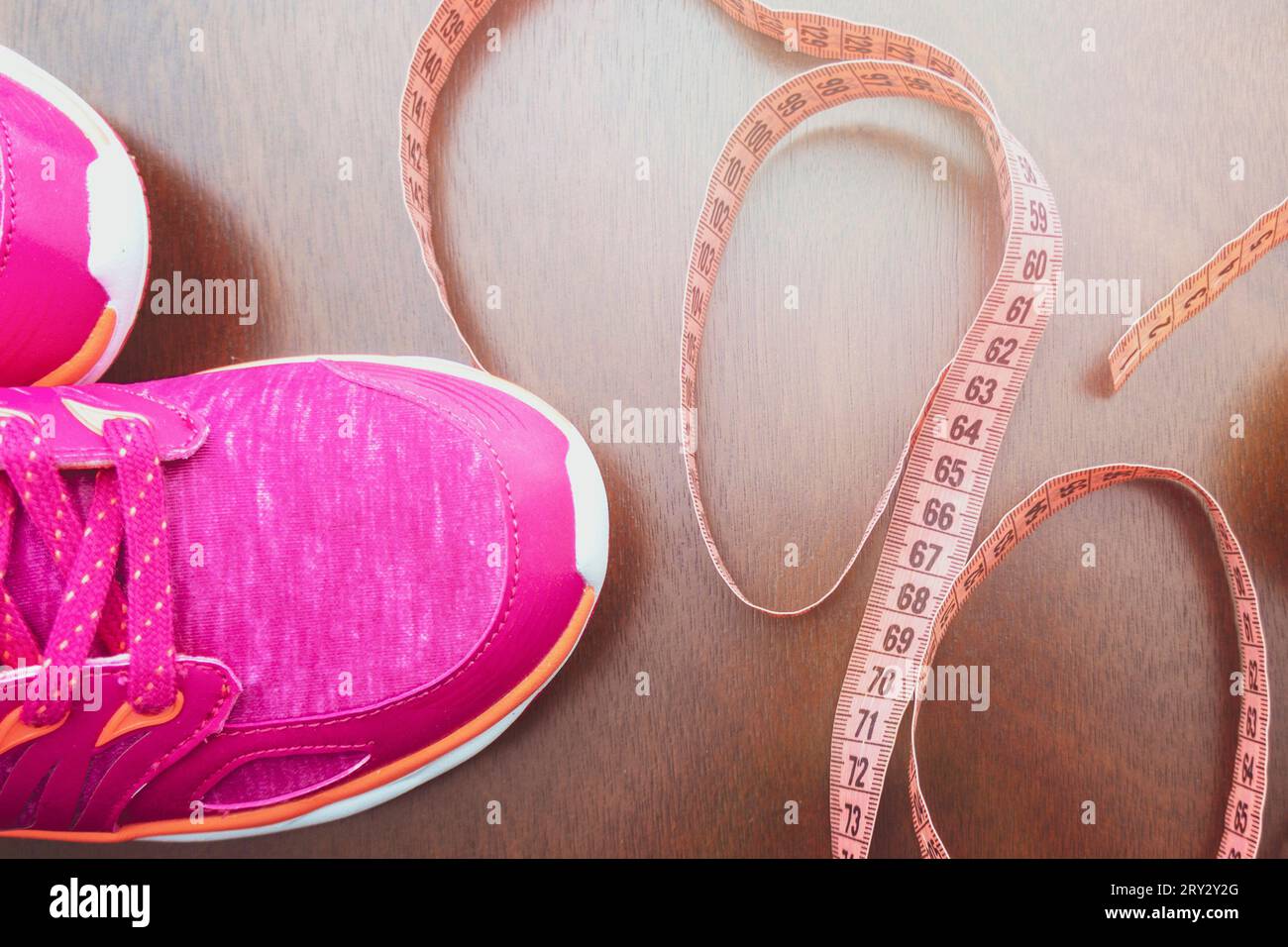 Close up. meter tape, pink sneakers. Concept Healthy way of life. Fitness accessories.The concept of sport. sneakers on background. The first step to Stock Photo