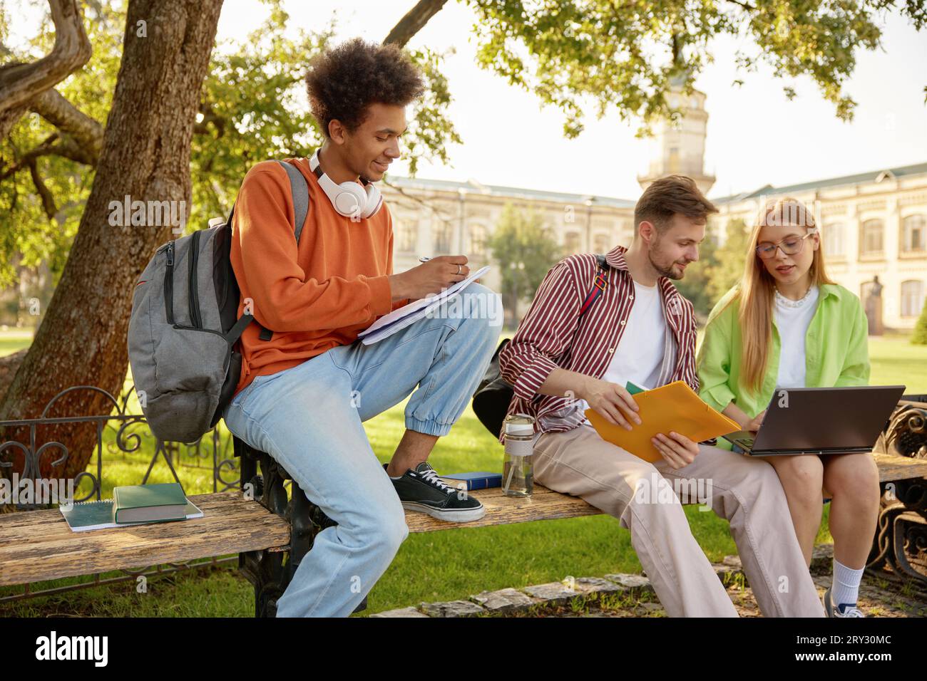 University students working on homework or creative project at campus outdoors Stock Photo