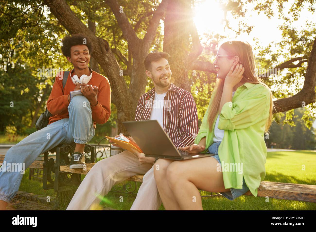Confident smiling university students chatting together while taking rest Stock Photo