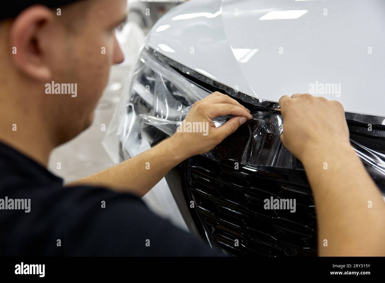 Protection film applying process in car garage Stock Photo Alamy